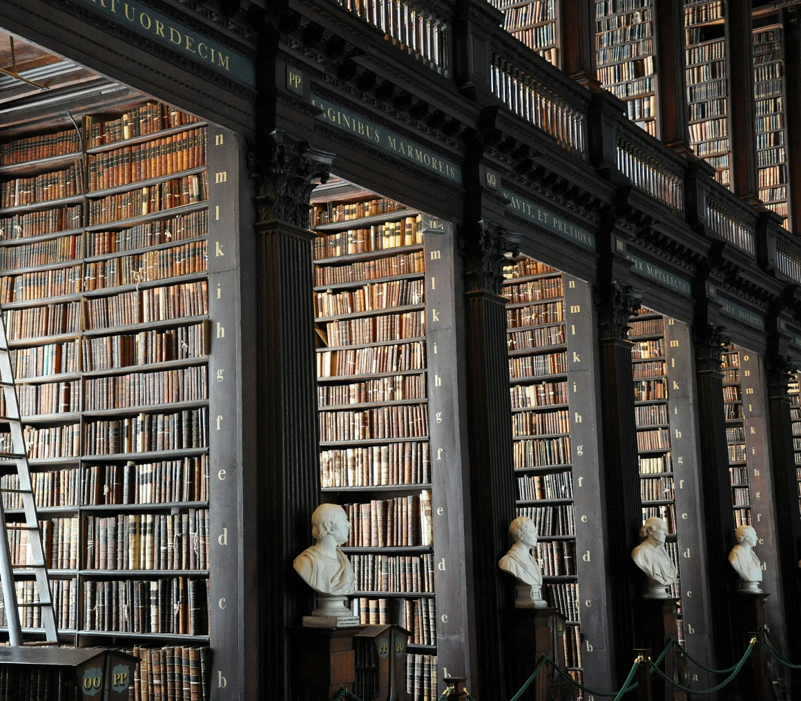 Historic library with shelves and busts.